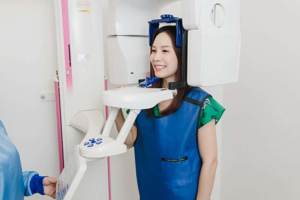 A patient standing in the CBCT 3D X-ray scanner at Kitcha Dental Clinic