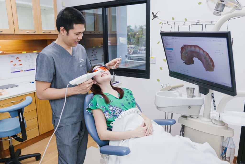 A dentist takes an intraoral scan while the 3D image shows on screen