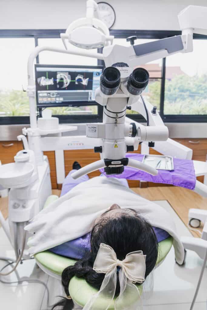 The dental operating microscope at Kitcha Dental Clinic, positioned over a patient in the treatment chair