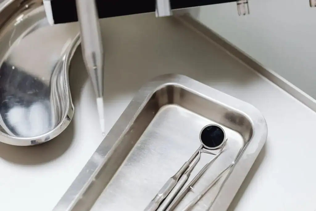 Dental handpieces above a tray of examination instruments