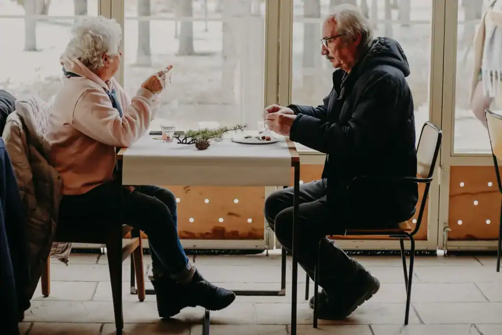 An older couple sharing a meal at a table by a window