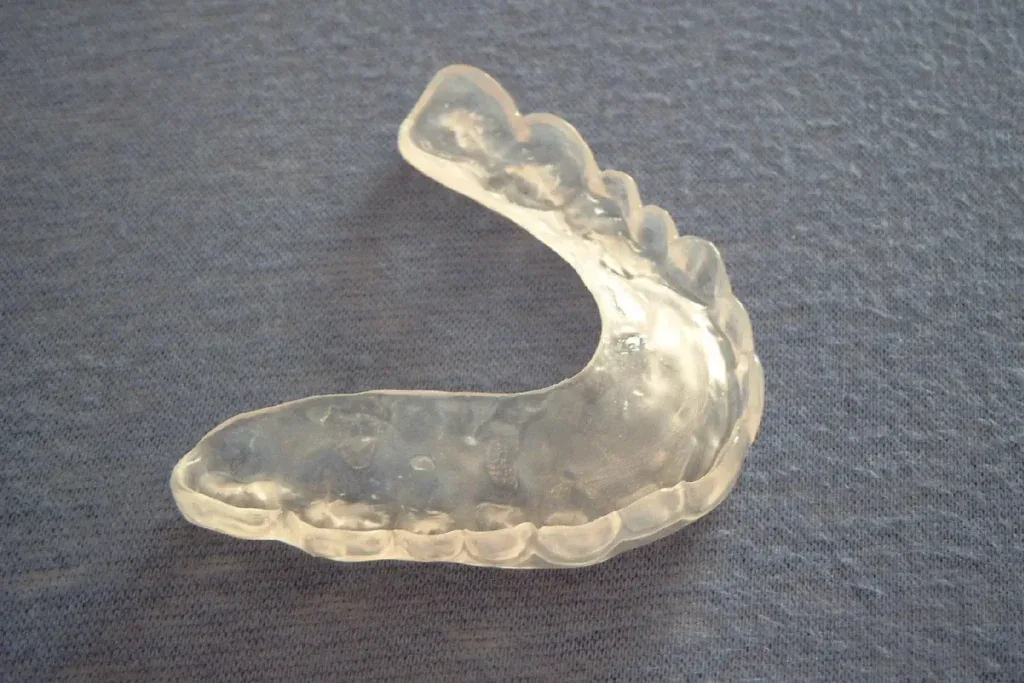 A clear occlusal splint for the upper teeth on a fabric surface