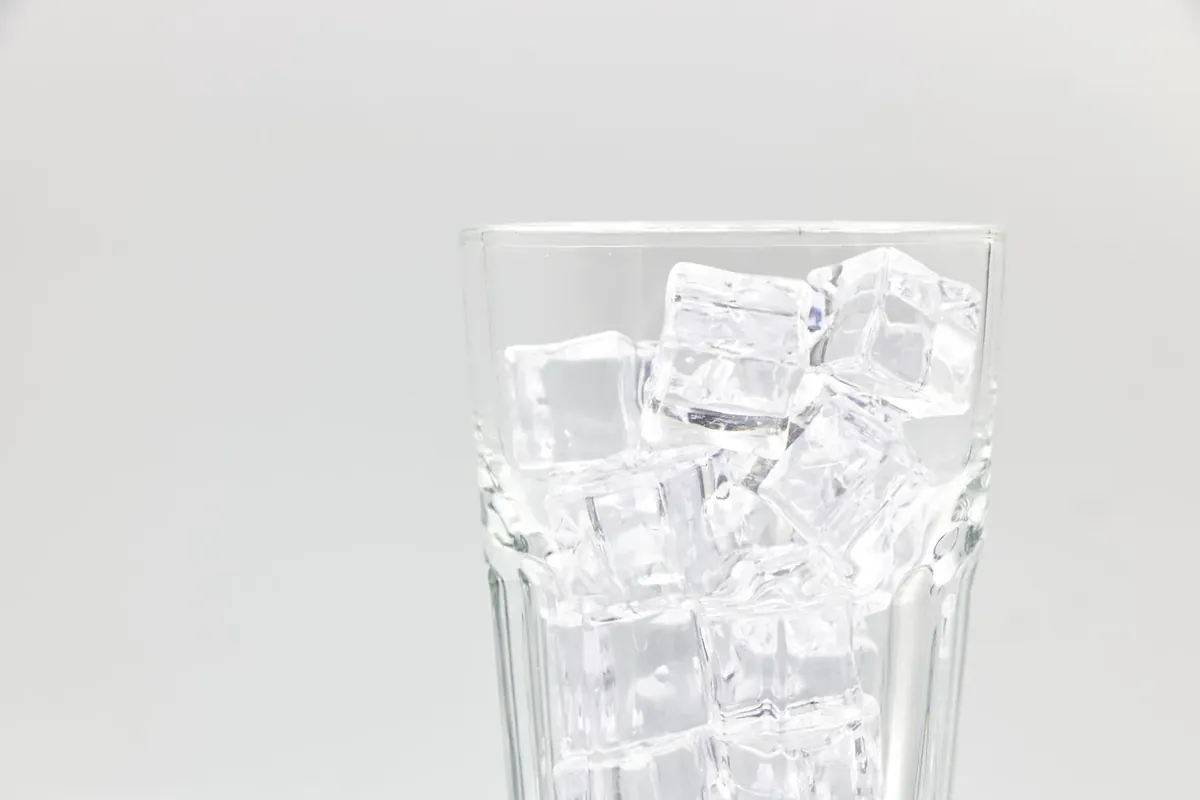 白色背景上装满冰块的玻璃杯