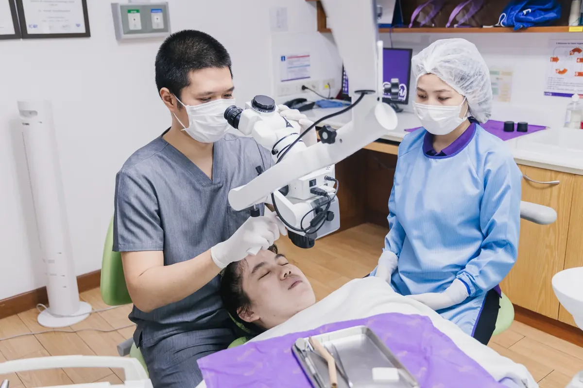 牙医在牙科显微镜下治疗牙齿