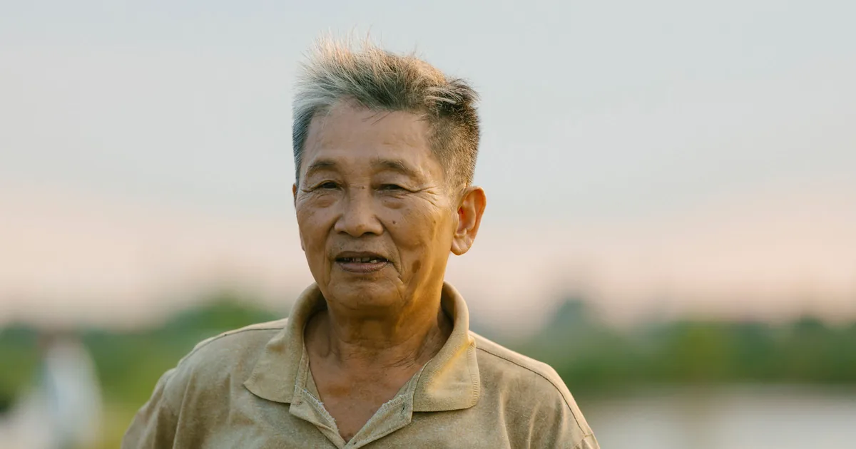 一位亚洲老年男士在傍晚温暖的光线中微笑
