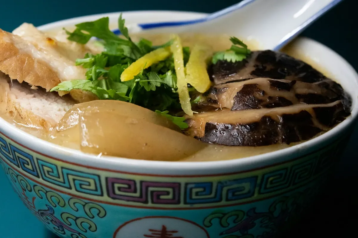 一碗配有香菇、姜丝和香菜的米粥,是牙齿松动期间容易进食的软食示例