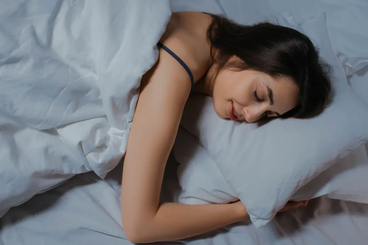 一位女士在白色床单上安然入睡