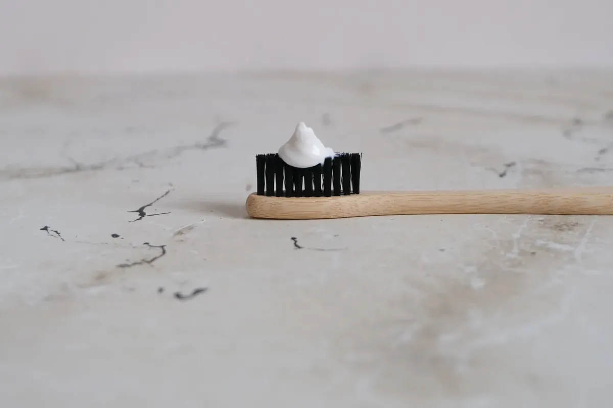 竹柄牙刷上挤了少量牙膏,放在大理石台面上