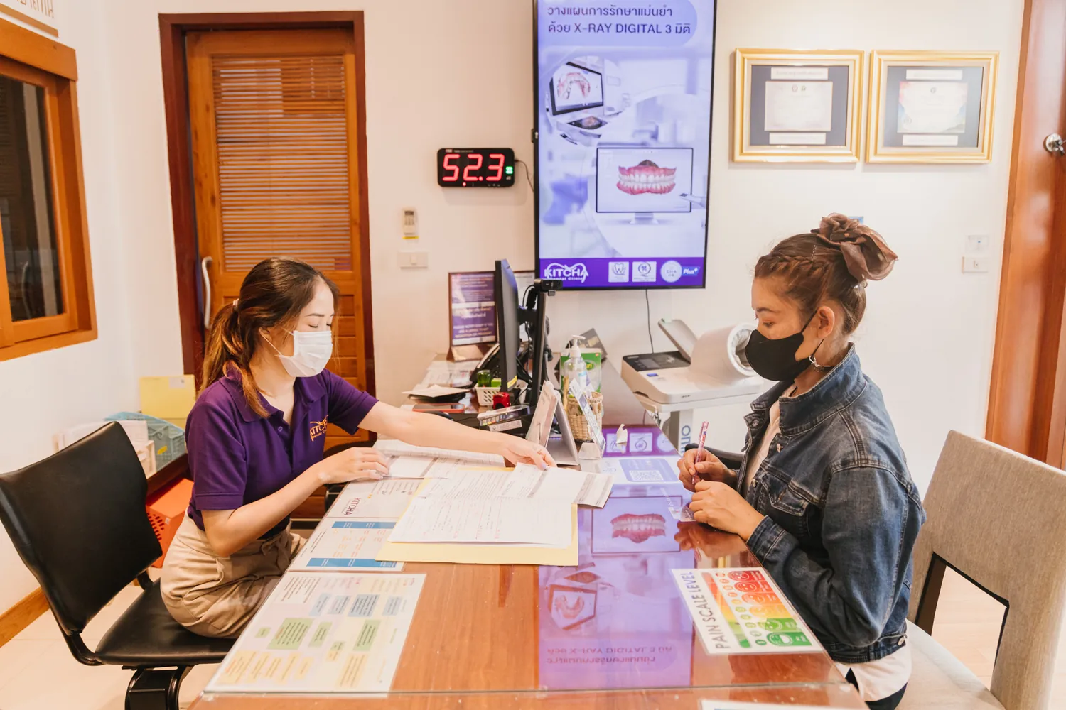 A team member explains the treatment plan and documents at the consultation desk